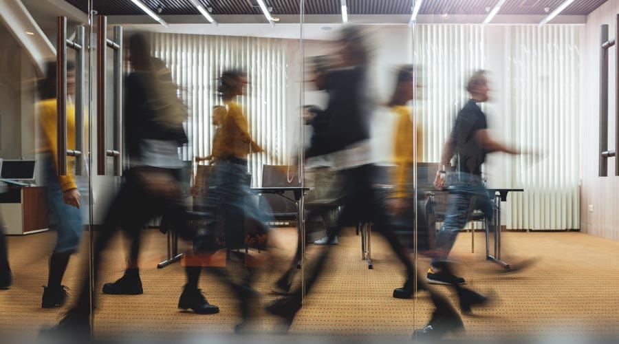 Motion blur of employees walking through a contemporary office hallway Motion blur of employees walking through a contemporary office hallway