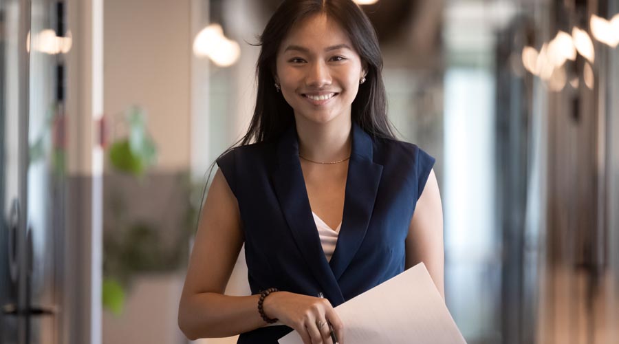 Confident business professional standing and smiling at the office