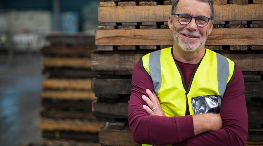 Logistics worker smiling while standing in a warehouse