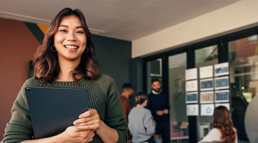 Smiling professional with a business meeting taking place in the background