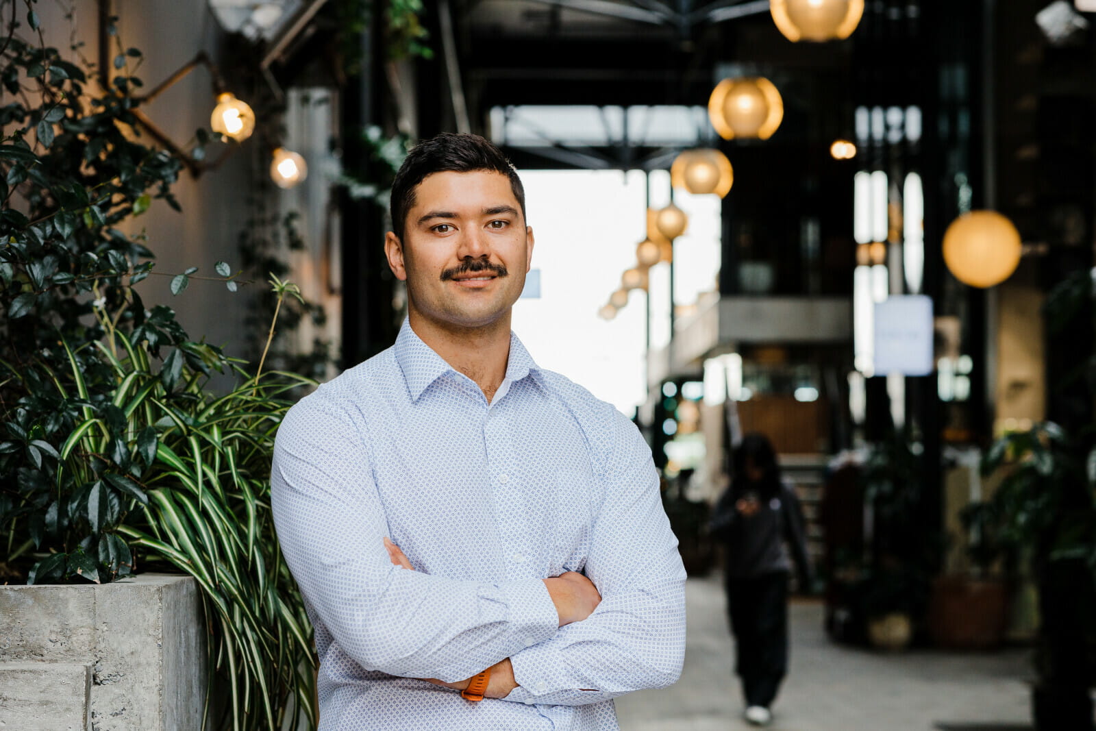 Smiling professional with strong mustache, confidently standing