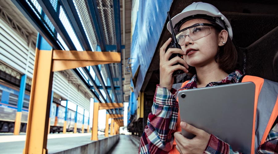 Female logistics worker  communicating using a  walkie-talkie