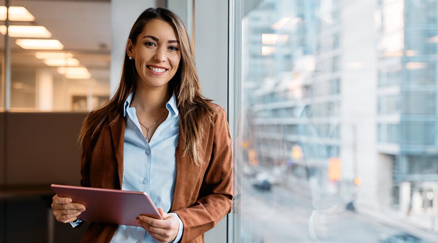 Smiling female  professional holding a red  tablet in an office