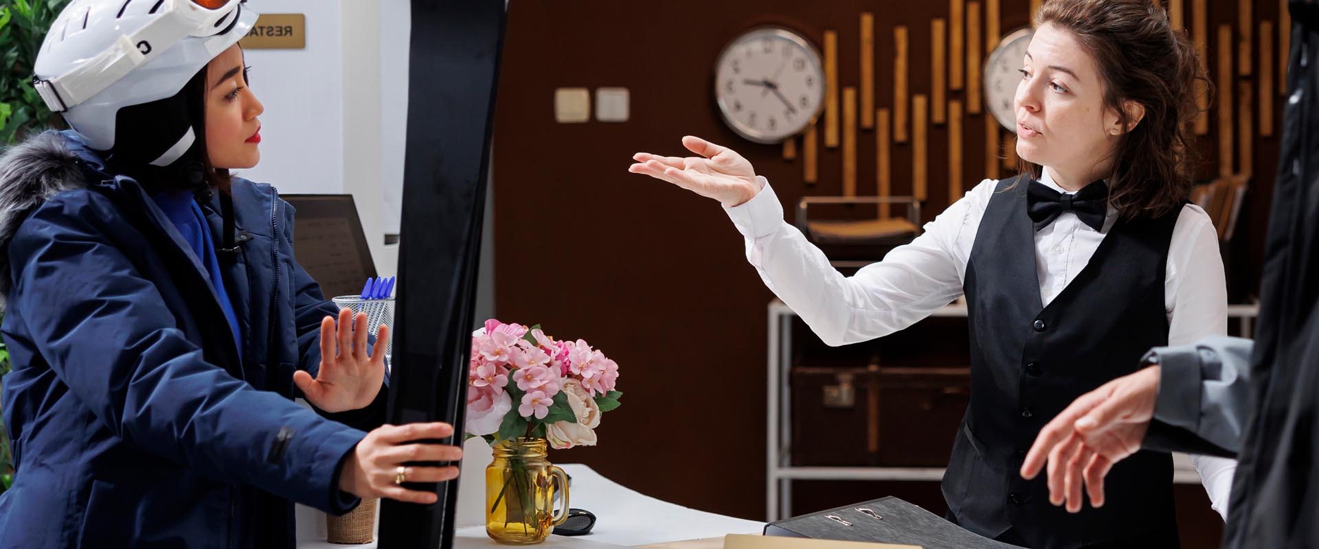 Hotel staff assisting  guests at the front desk  with a welcoming smile