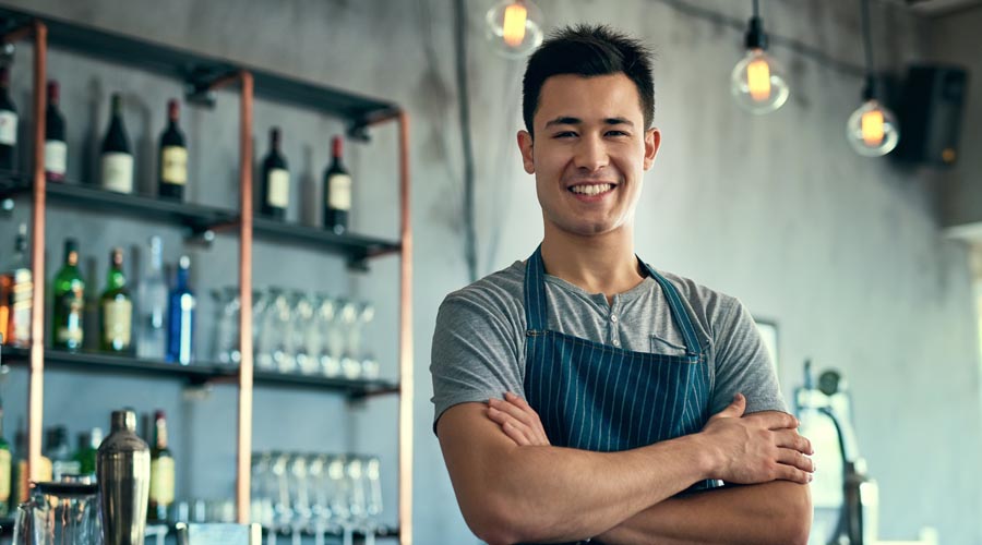 Friendly bar staff member  standing behind the  counter