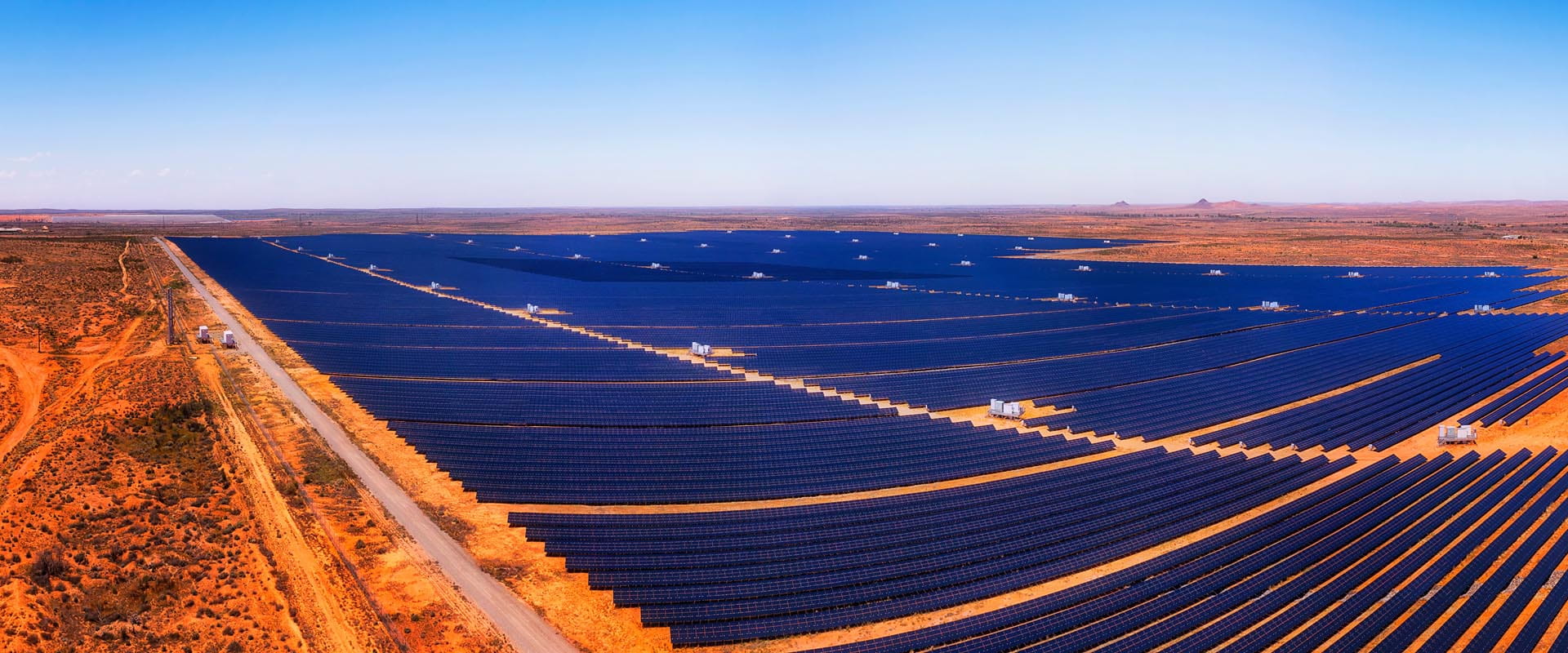 Expansive solar panel  farm with a sunset in the  background