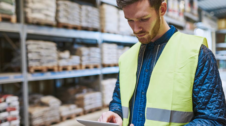 Warehouse worker using a  tablet to track inventory