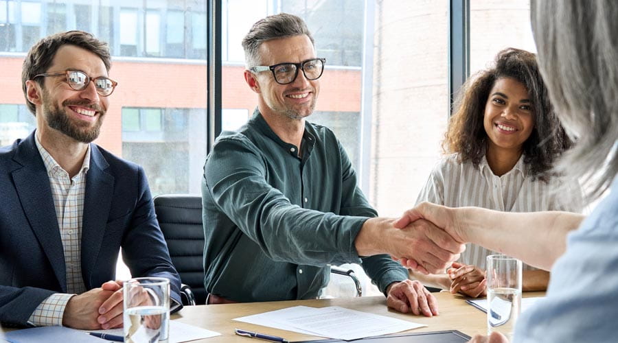 Candidate and interviewer  shaking hands during a  group intervie