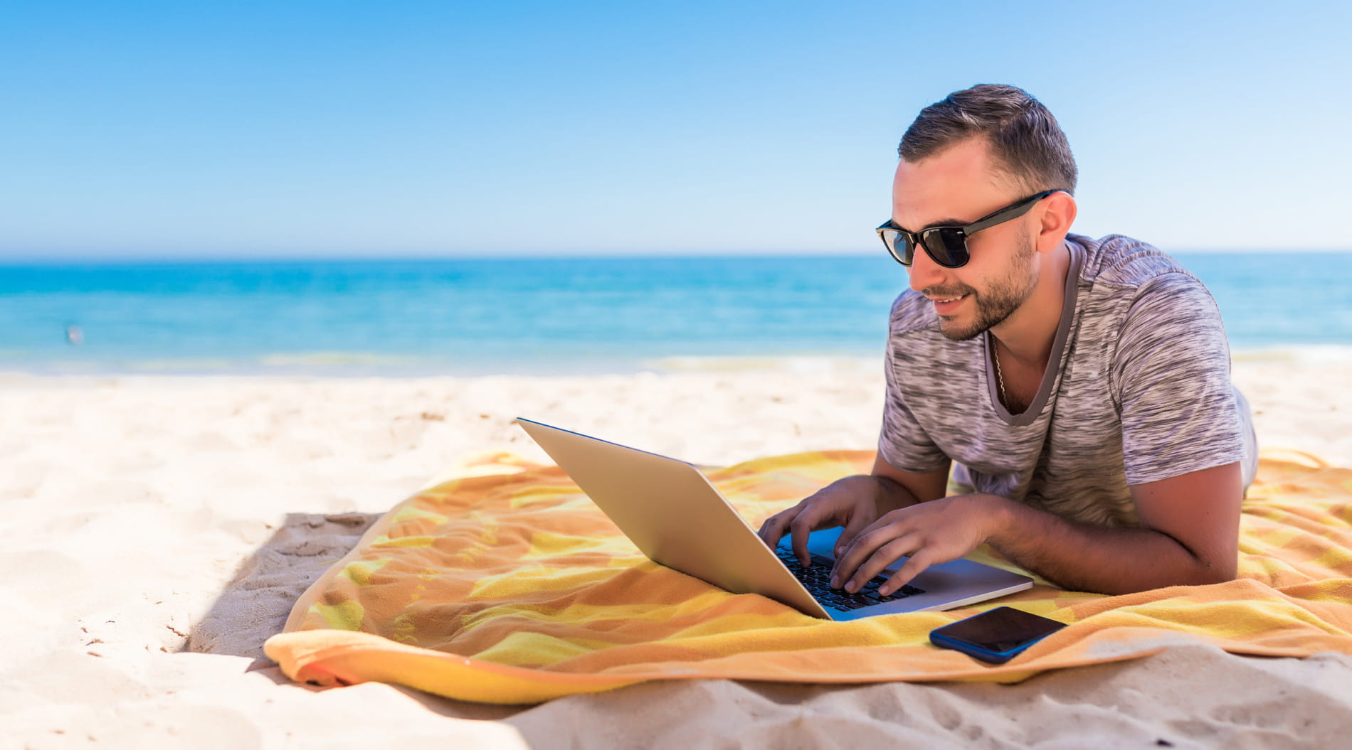Person using laptop on beach