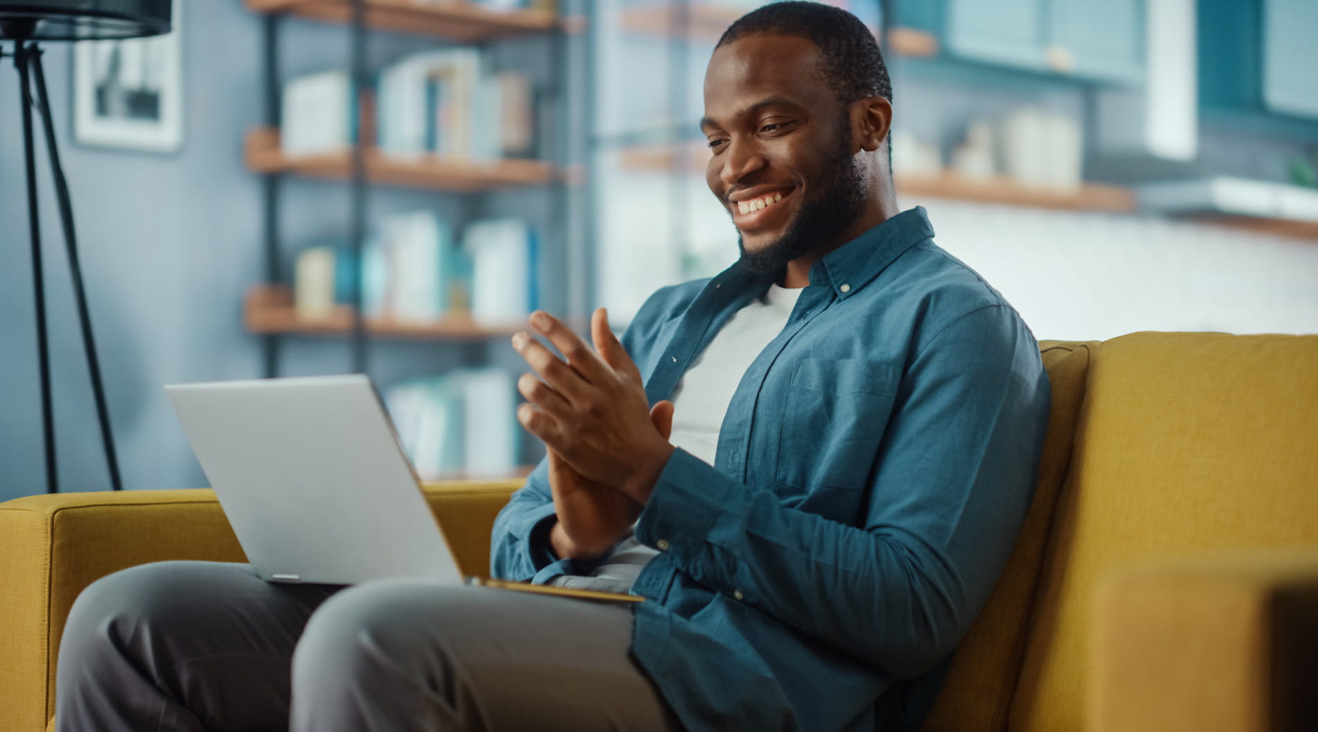 Person on yellow couch using laptop, upskilling for career success