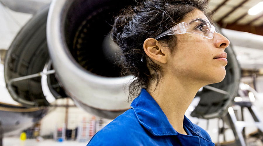Technician inspecting aircraft engine in hangar Technician inspecting aircraft engine in hangar