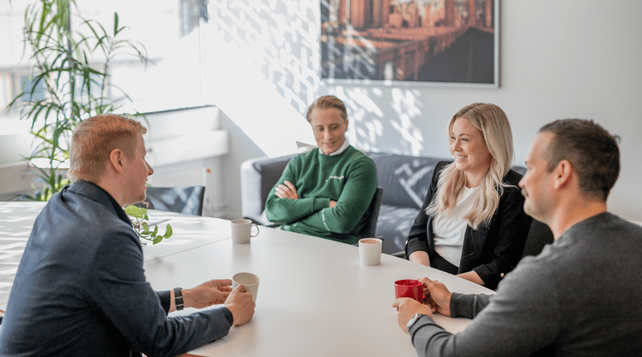 Team sitter och samtalar glatt i möte