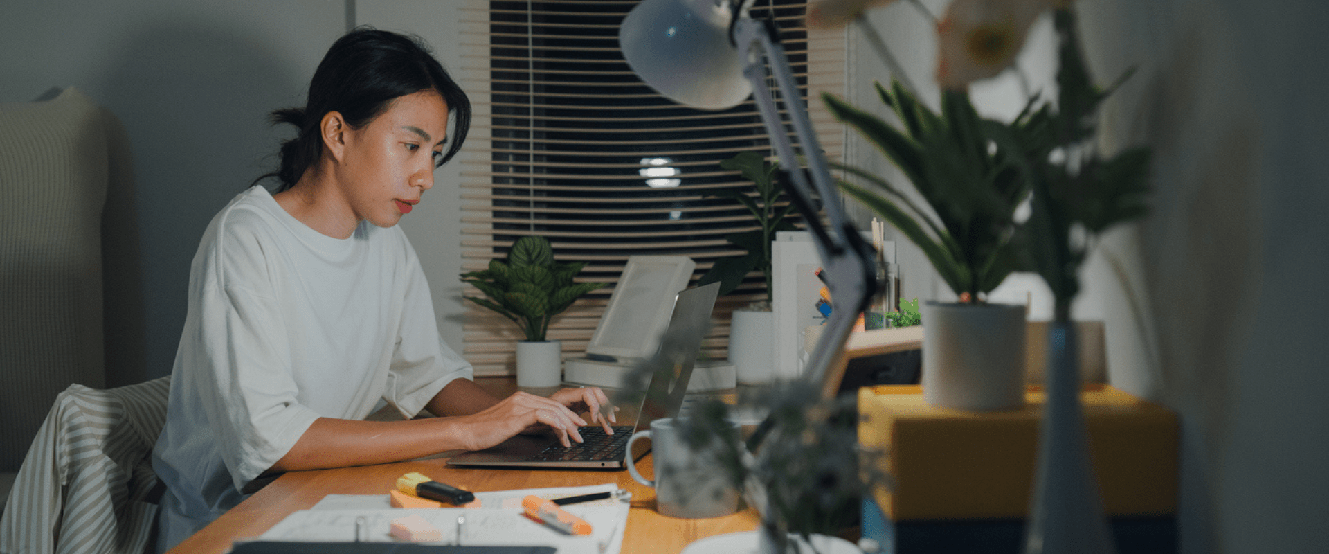 A person types on a laptop in their home office. A person types on a laptop in their home office.