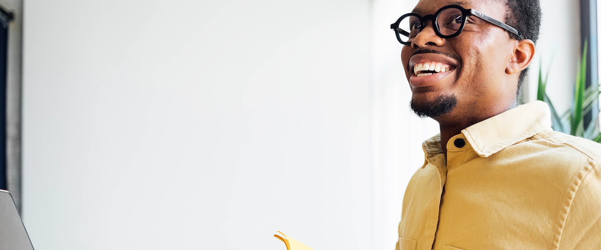 Homme souriant tout en travaillant dans un espace de bureau lumineux