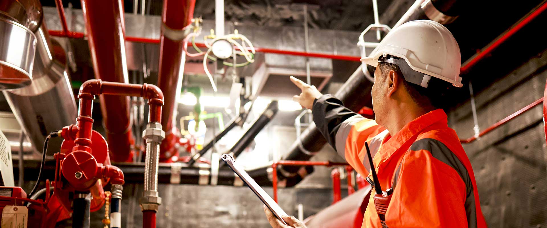Travailleur installant de la tuyauterie industrielle dans une installation de construction