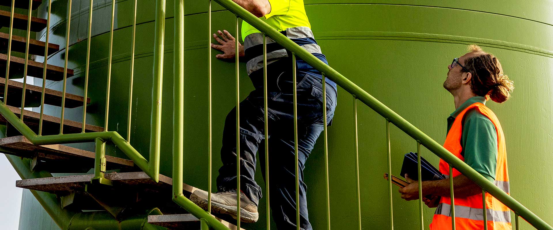 Twee medewerkers lopen trap op in veiligheidsuitrusting