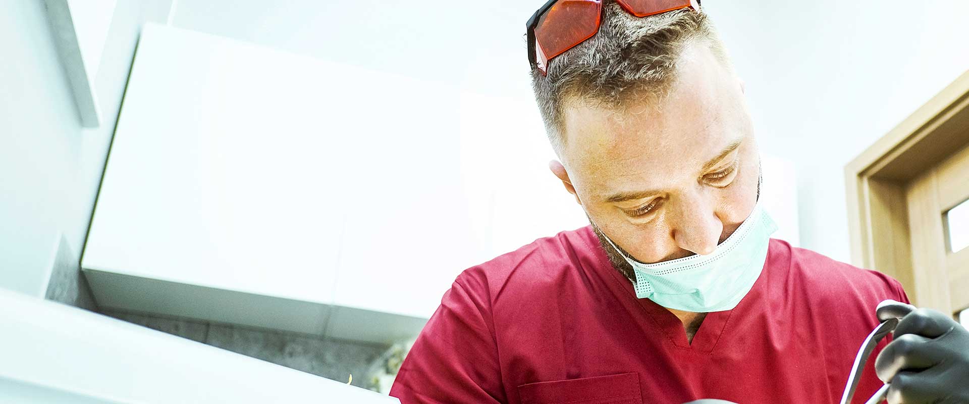 Un dentiste et son assistante portant un masque et des gants travaillent sur un patient