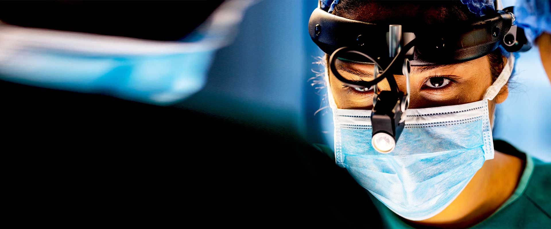 Surgeon wearing mask and magnifying loupes during procedure