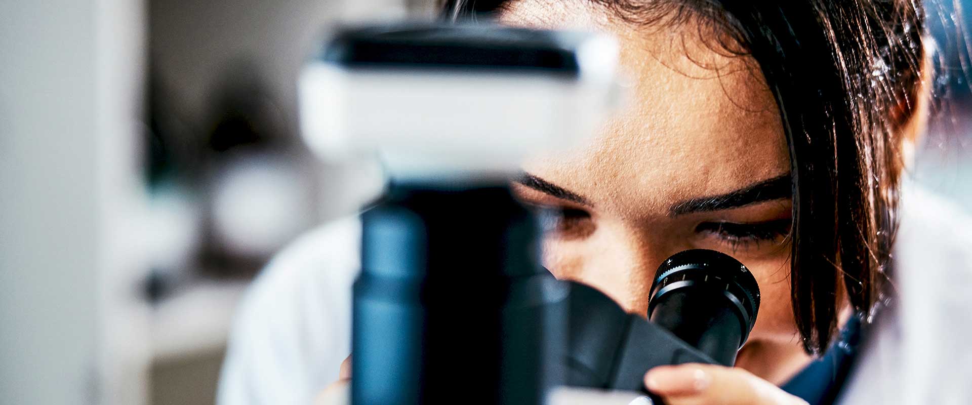 Professionnel de laboratoire regardant dans un microscope