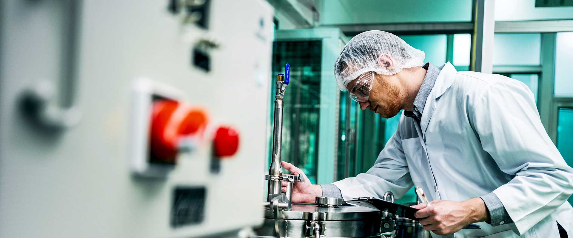 Tehnician care operează panoul de control în mediul de producție