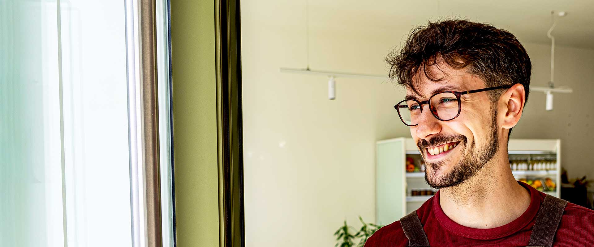 Employé de vente au détail debout à l'entrée du magasin en souriant