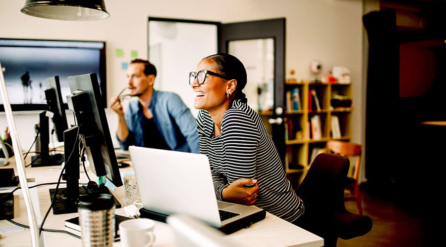Professionnels travaillant ensemble à l'ordinateur dans un bureau