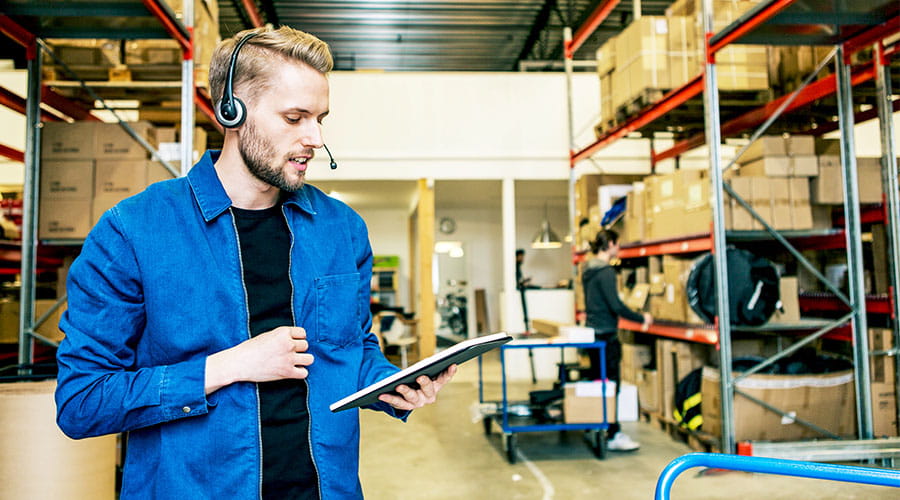Employé d'entrepôt vérifiant l'inventaire avec un presse papiers