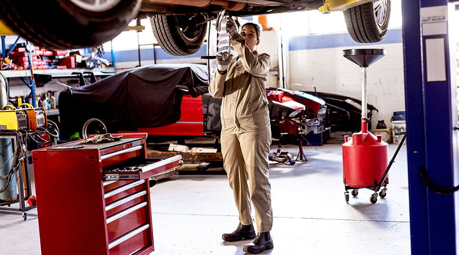 Technicien automobile travaillant dans un atelier automobile avec des outils