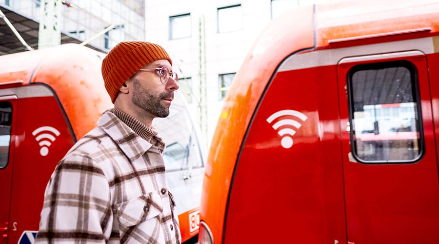 Medewerker staat naast rode bestelwagen in depot