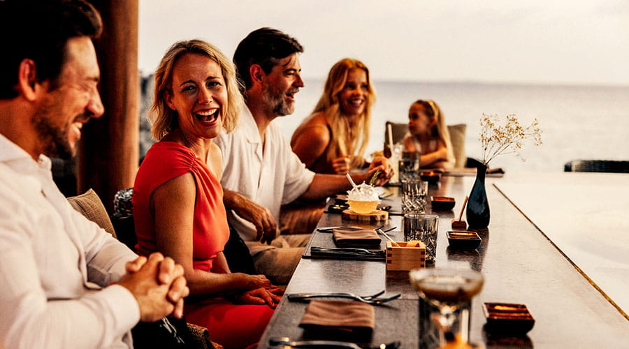 Group of people enjoying meal together at restaurant table