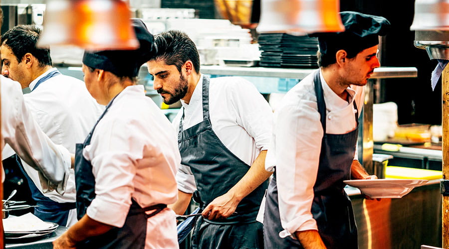 Chefs working together in busy commercial kitchen