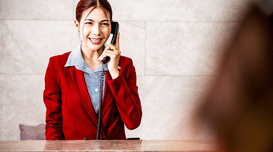 La réceptionniste parle au téléphone à la réception de l'hôtel.