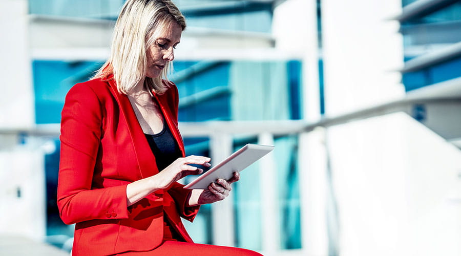 Woman reviewing construction plans on site with tablet Woman reviewing construction plans on site with tablet