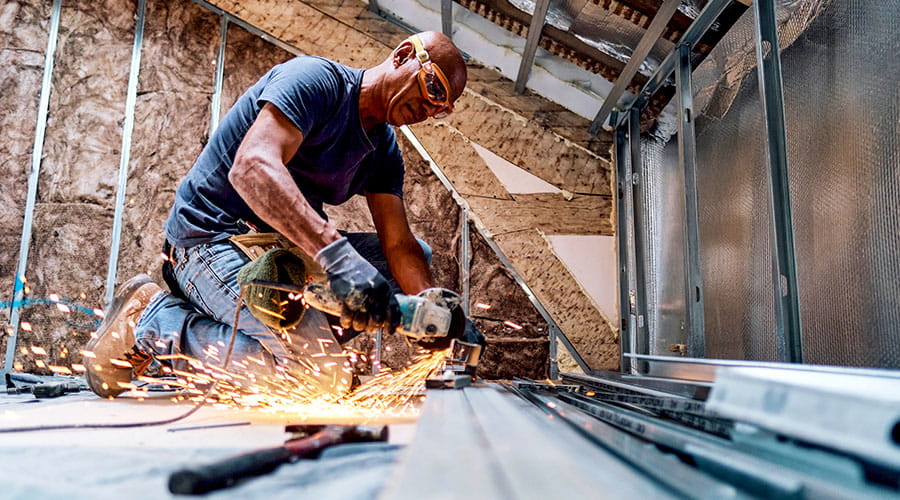 Medewerker snijdt materialen in werkplaats