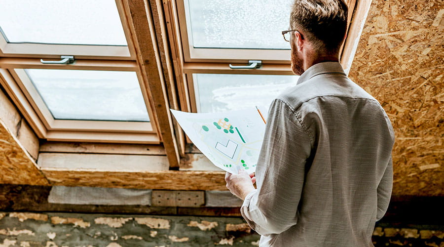 Person reviewing architectural plans indoors
