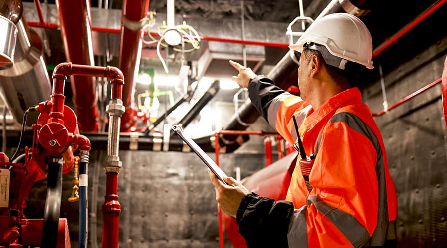 Engenheiros a rever planos no interior de uma instalação industrial