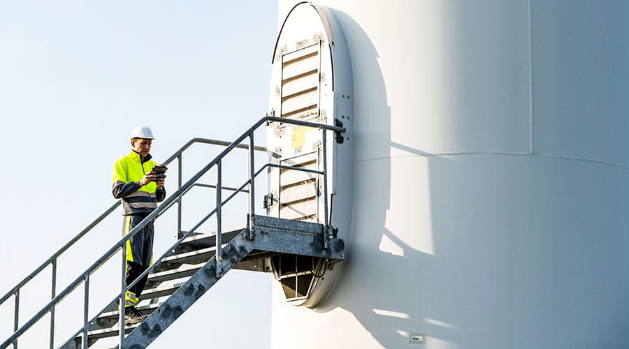 Technician working on wind turbine at height Technician working on wind turbine at height