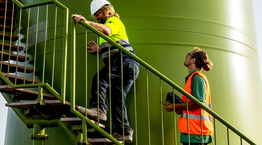 Medewerkers lopen op platform in industriële faciliteit