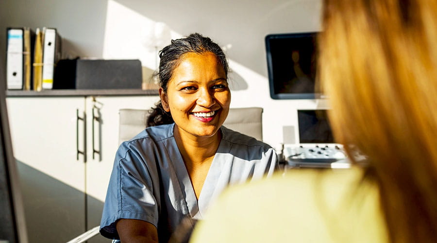 Nurse talking with patient at desk