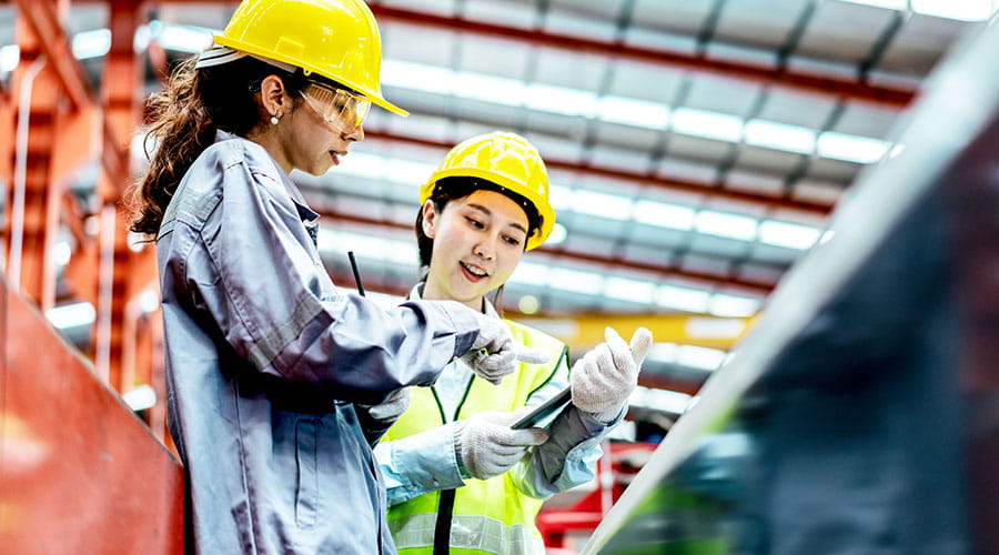Deux travailleurs examinant des plans dans l'atelier de l'usine