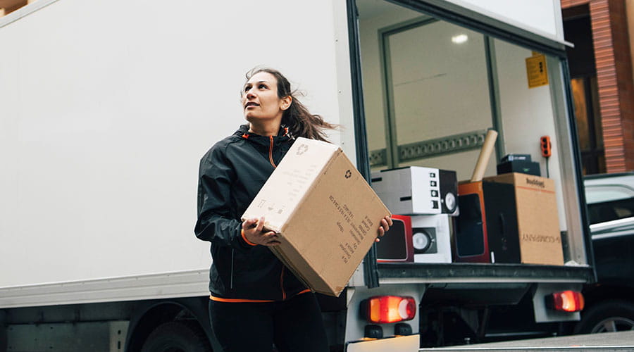 Delivery worker carrying parcel outside building