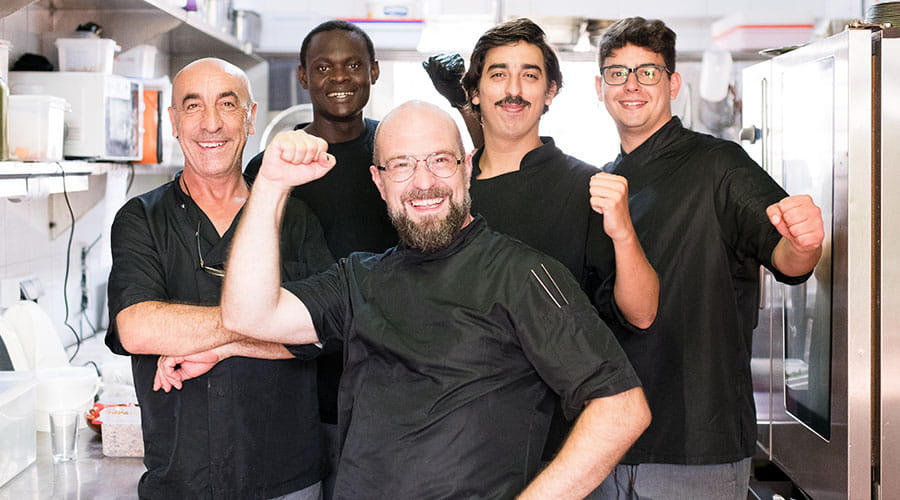 Team chefs poseert samen in professionele keuken