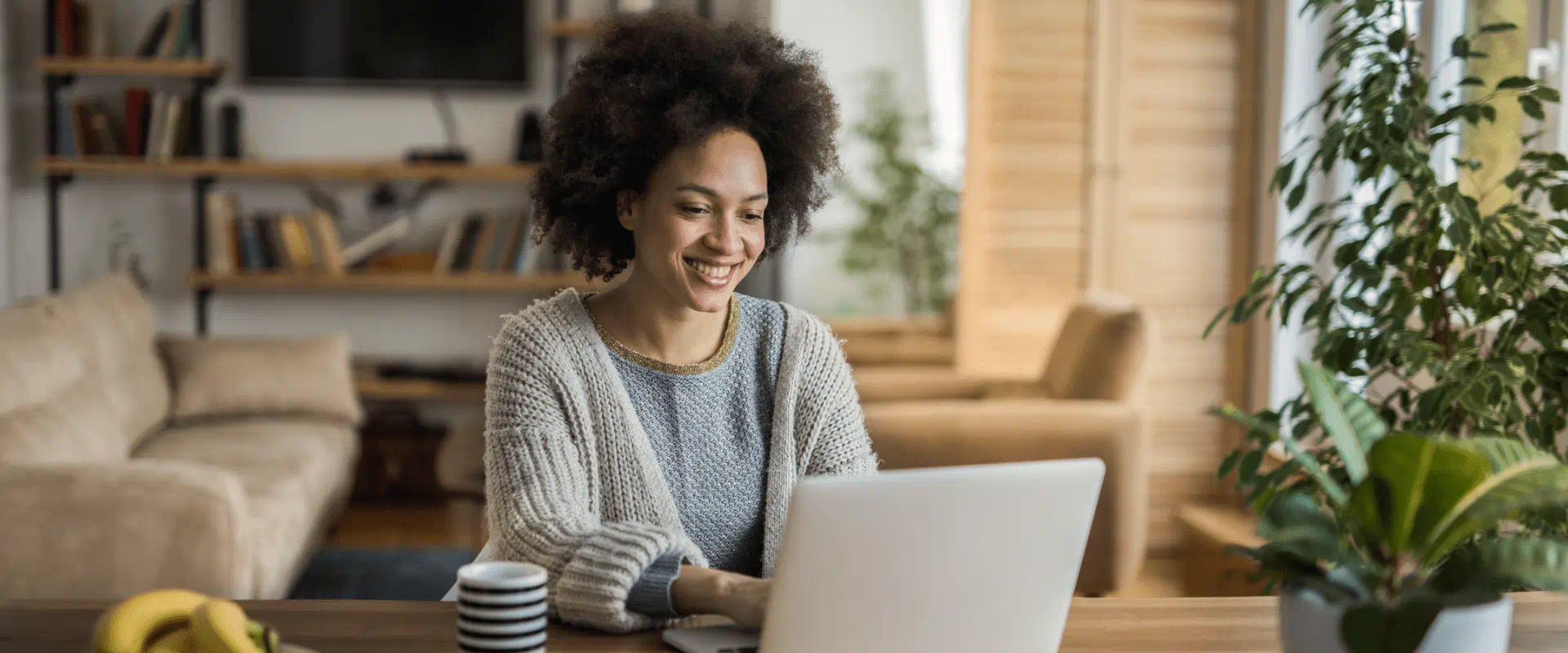 A person sits at their kitchen table at their laptop. A person sits at their kitchen table at their laptop.