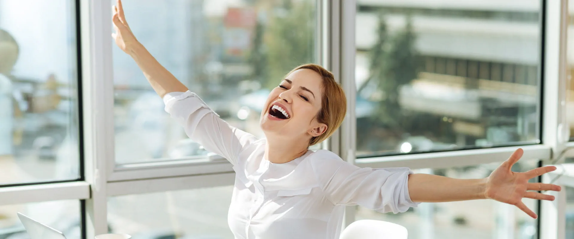 Excited person in a bright office, smiling with arms outstretched, celebrating a successful moment. Excited person in a bright office, smiling with arms outstretched, celebrating a successful moment.