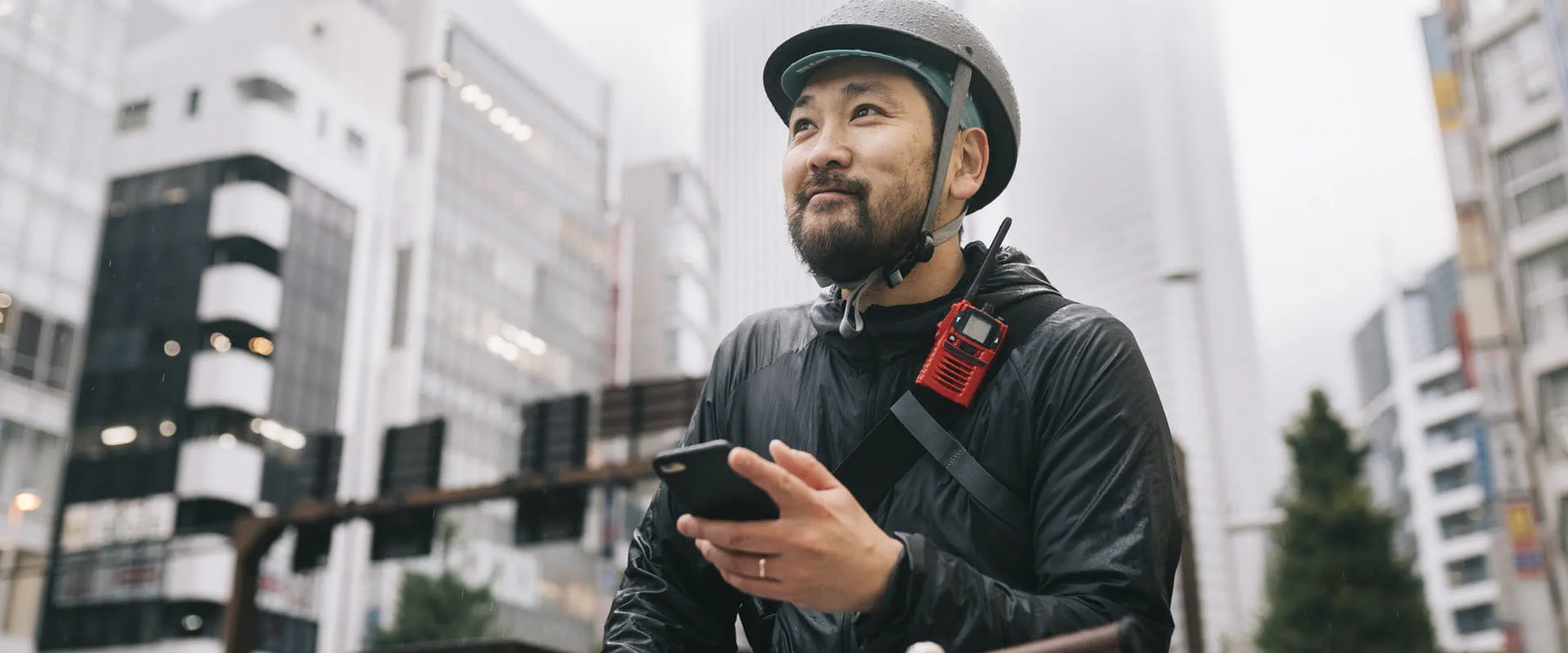 A bike messenger looks up from his phone optimistically. A bike messenger looks up from his phone optimistically.