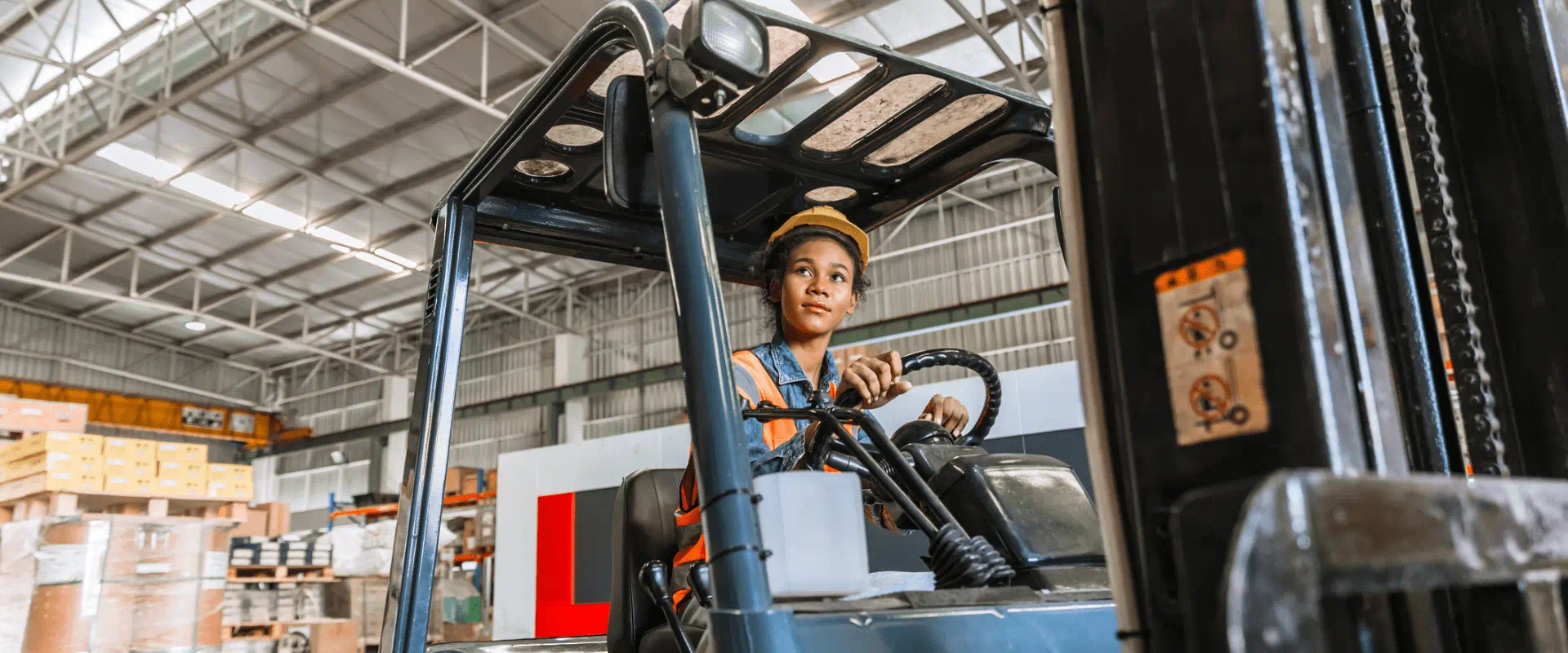 A worker operates a forklift in a warehouse