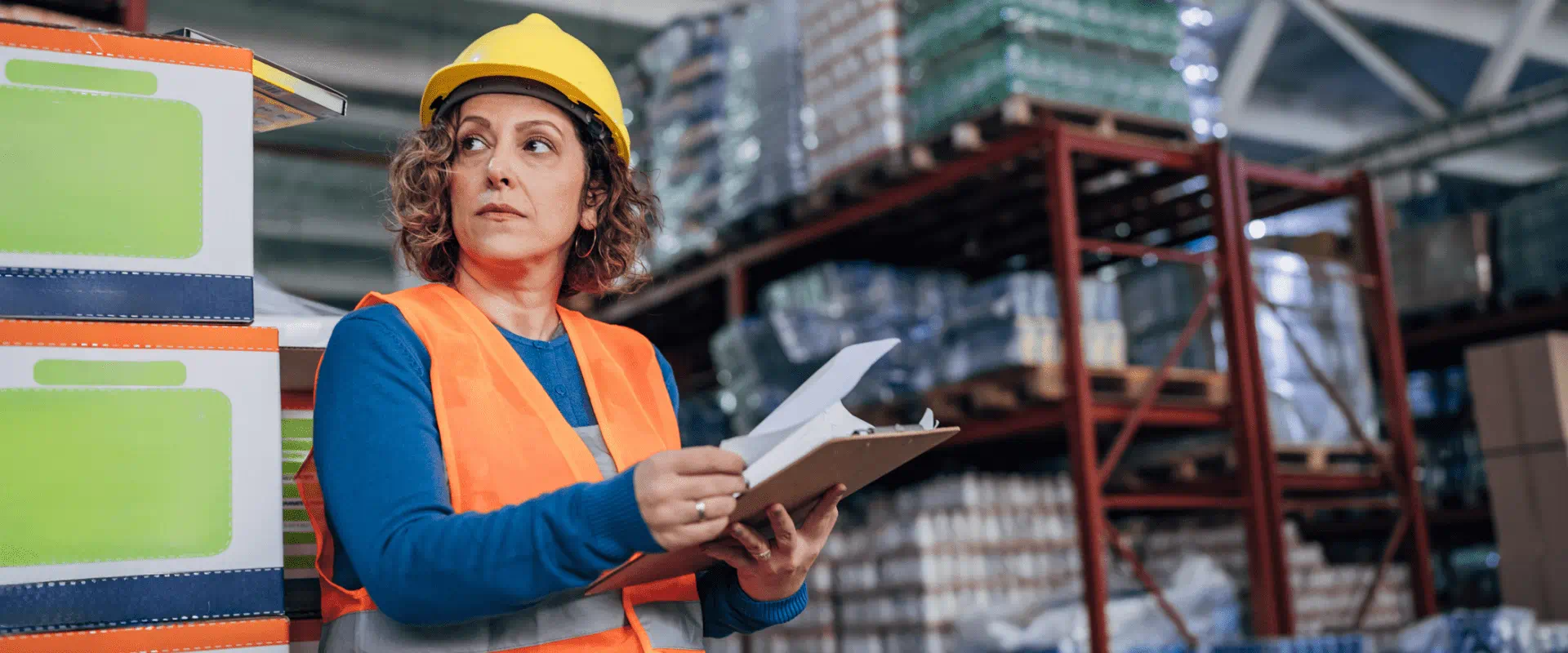 A manager in a warehouse holds a clipboard A manager in a warehouse holds a clipboard