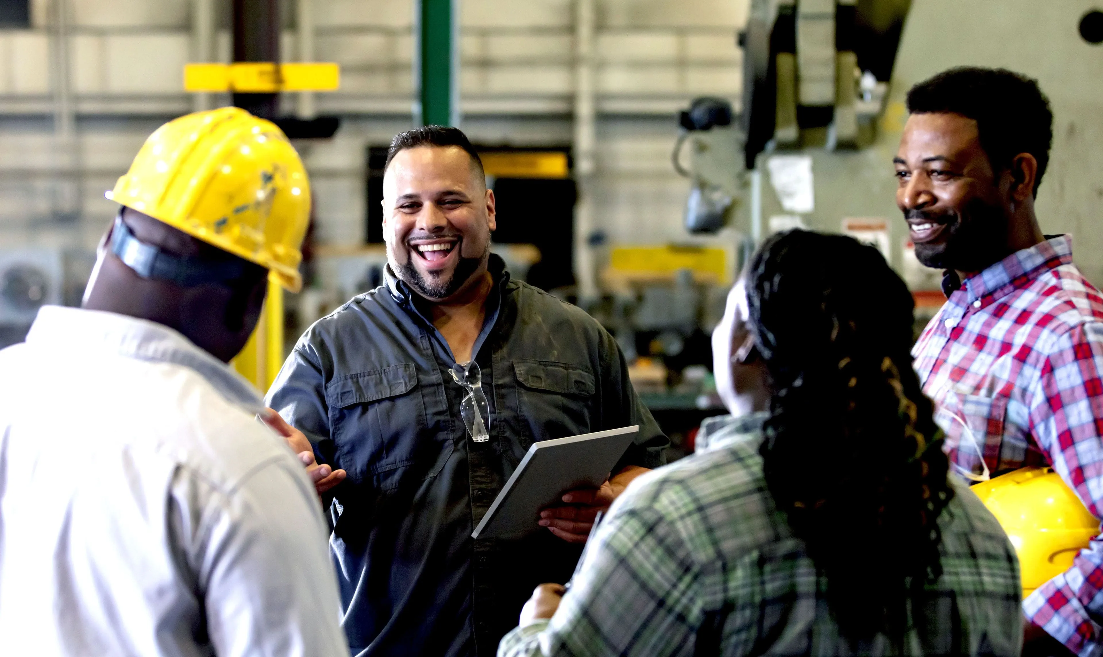 A group workers meeting in a metal fabrication shop A group workers meeting in a metal fabrication shop