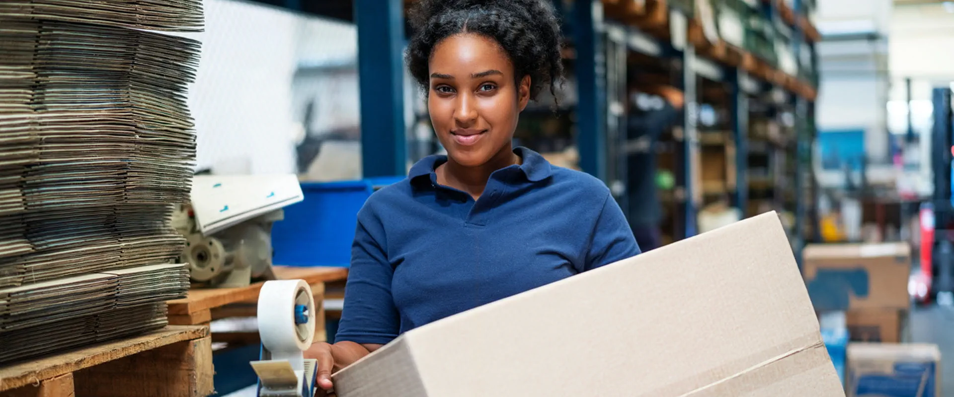 Worker moving a box in distribution warehouse. Worker moving a box in distribution warehouse.
