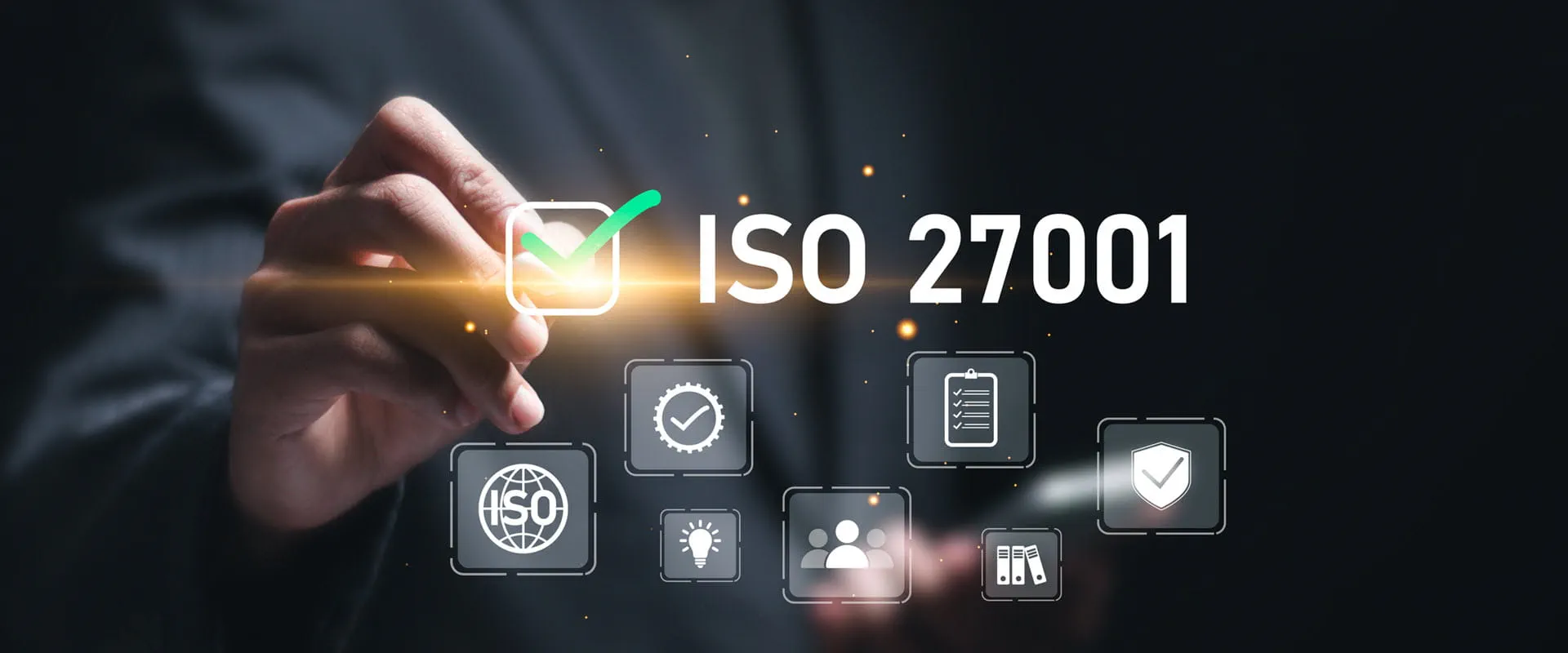 Hand pointing towards a glowing checkmark symbol next to the text 'ISO 27001,' representing information security certification. Hand pointing towards a glowing checkmark symbol next to the text 'ISO 27001,' representing information security certification.